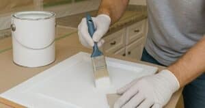 man-painting-cabinet-in-white