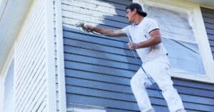 man spraying the exterior wall