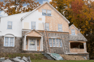 Home-renovation-exterior-remodel-project-with-siding-replacement-and-restoration-work-in-progress.