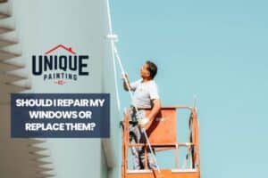 man painting the exterior wall with a caption Should I repair my windows or replace them?