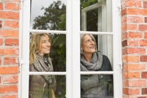 daughter and mother looking through window