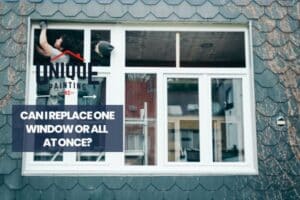 workers installing window with a caption Can I Replace One Window or All at Once?